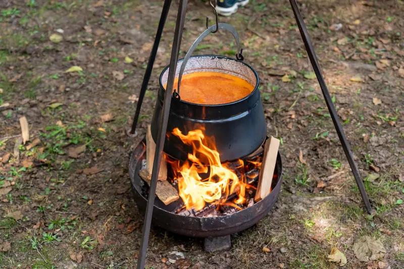 A black pot over a campfire cooking food outdoors in Garešnica, Croatia