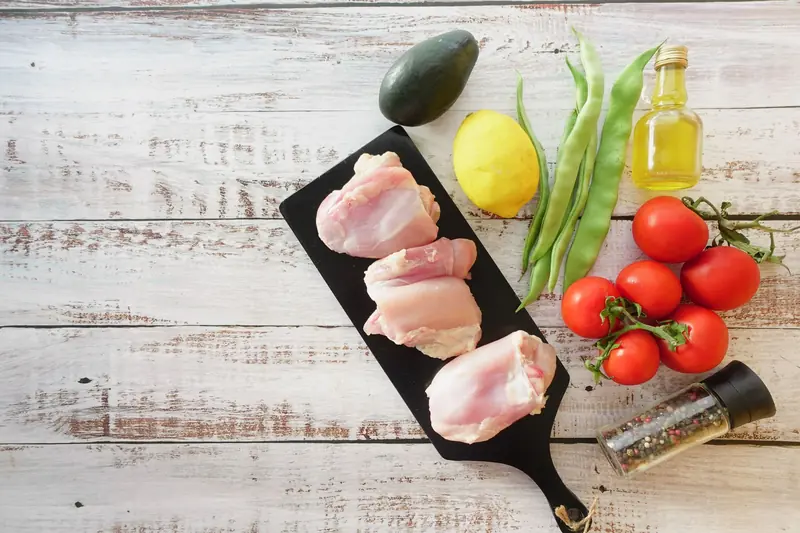 A variety of fresh ingredients including chicken, vegetables, and spices ready for a healthy meal