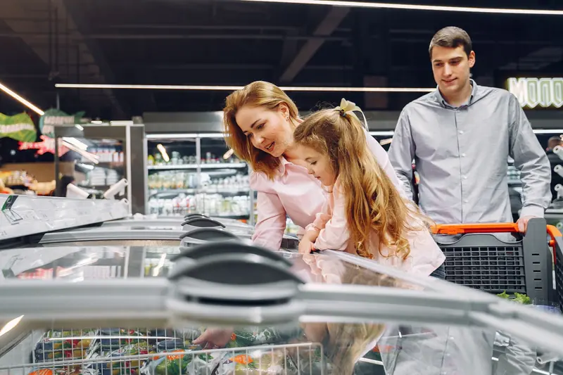 A happy family shopping in the supermarket's freezer section, emphasizing togetherness and love