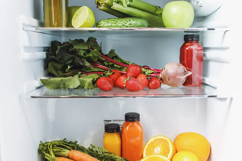 Colorful array of fresh fruits and vegetables neatly arranged in a refrigerator