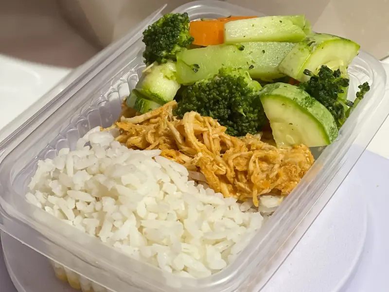 A nutritious meal prep box with rice, shredded chicken, and mixed vegetables